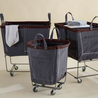 Rolling dark gray laundry baskets with black frames and wheels. Handles on top