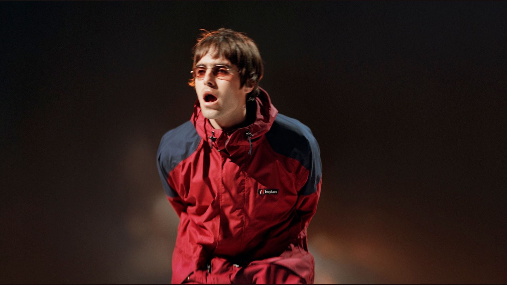 Liam Gallagher performing in 1997 wearing a red Berghaus Meru Jacket 