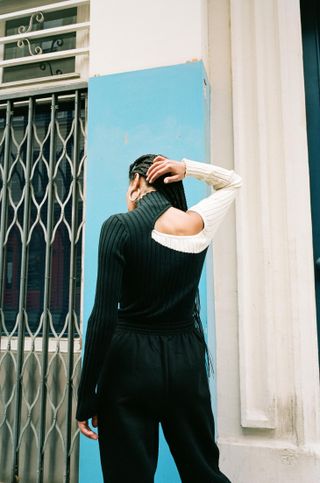 Woman with back to camera wearing cut out sweater