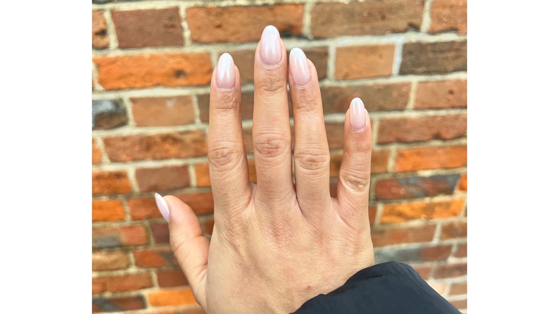 On the left is a close-up of Digital Ecom Editor, Aleesha Badkar's chrome pink almond nails taken in front of a brick wall background