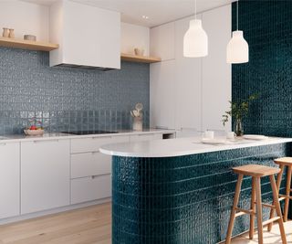 kitchen with blue tiled splashback, wall and base of kitchen island, white cabinets and pale wooden flooring