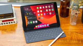 Bedste billige tablets: Et billede af en iPad 10.2 på et træbord med en stylus liggende på tastaturet.