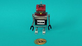 A SCAM-labeled robot bends over a bitcoin coin and looks at it.