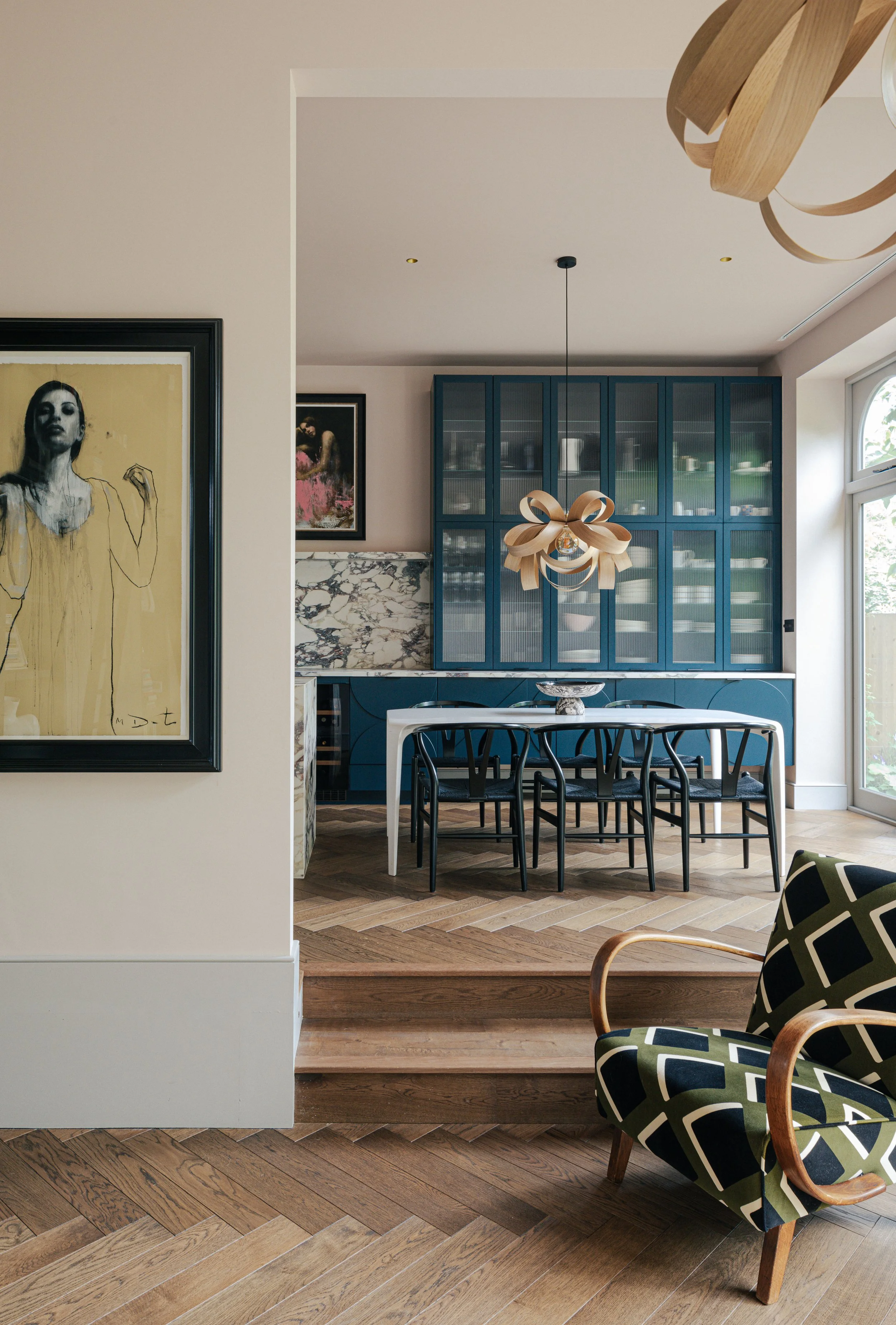Glamorous dining area with floor-to-ceiling blue-painted cabinetry with reeded glass