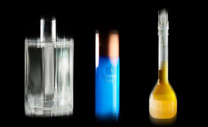 Oumere skincare serum in yellow test tube-like bottle, augustinus bader skincare in blue bottle, and Hermes H24 perfume in clear glass bottle against black background
