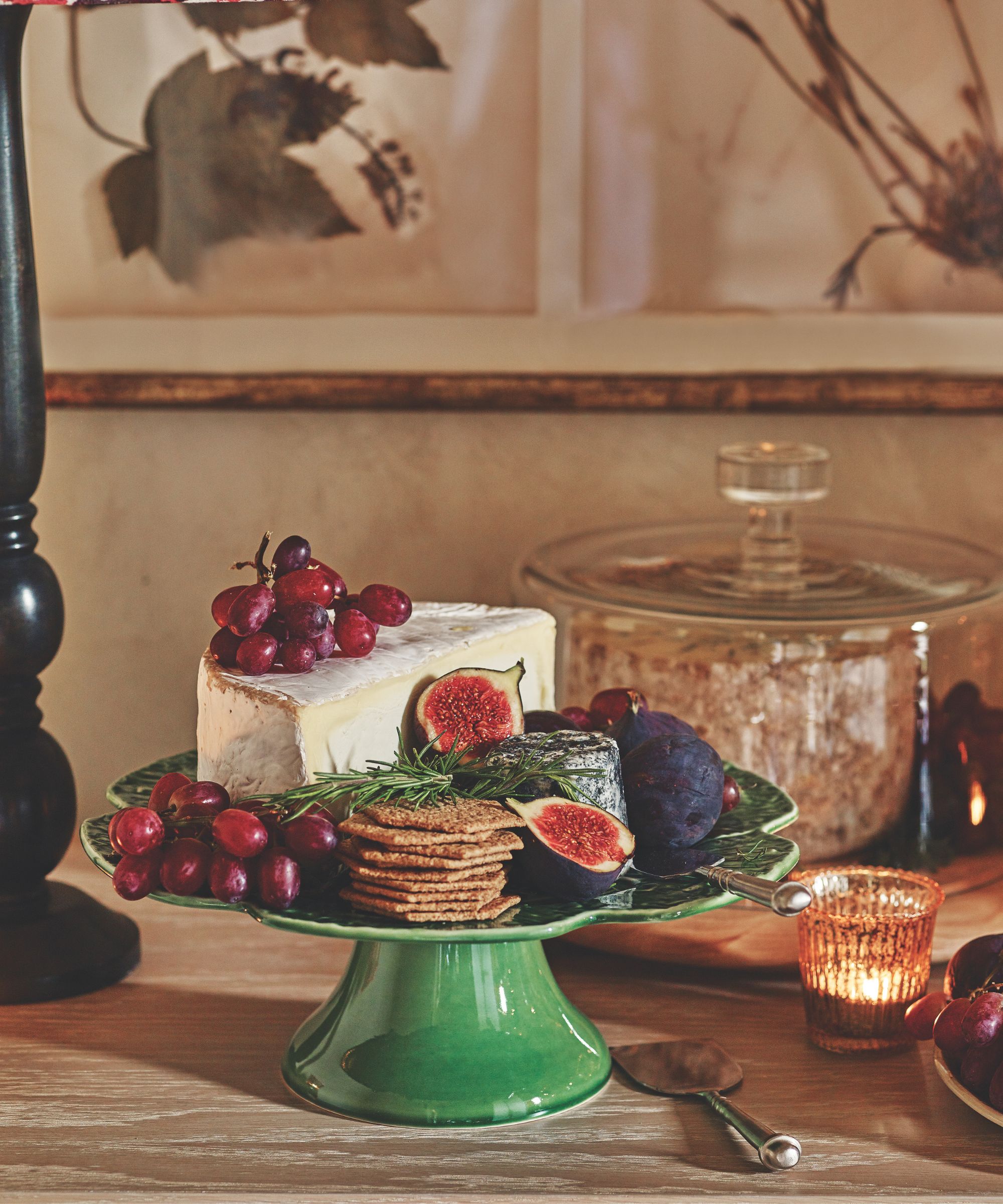 Cheese and figs and grapes on a green cake stand