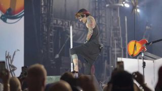 Tommy Lee onstage fumbling with his pants