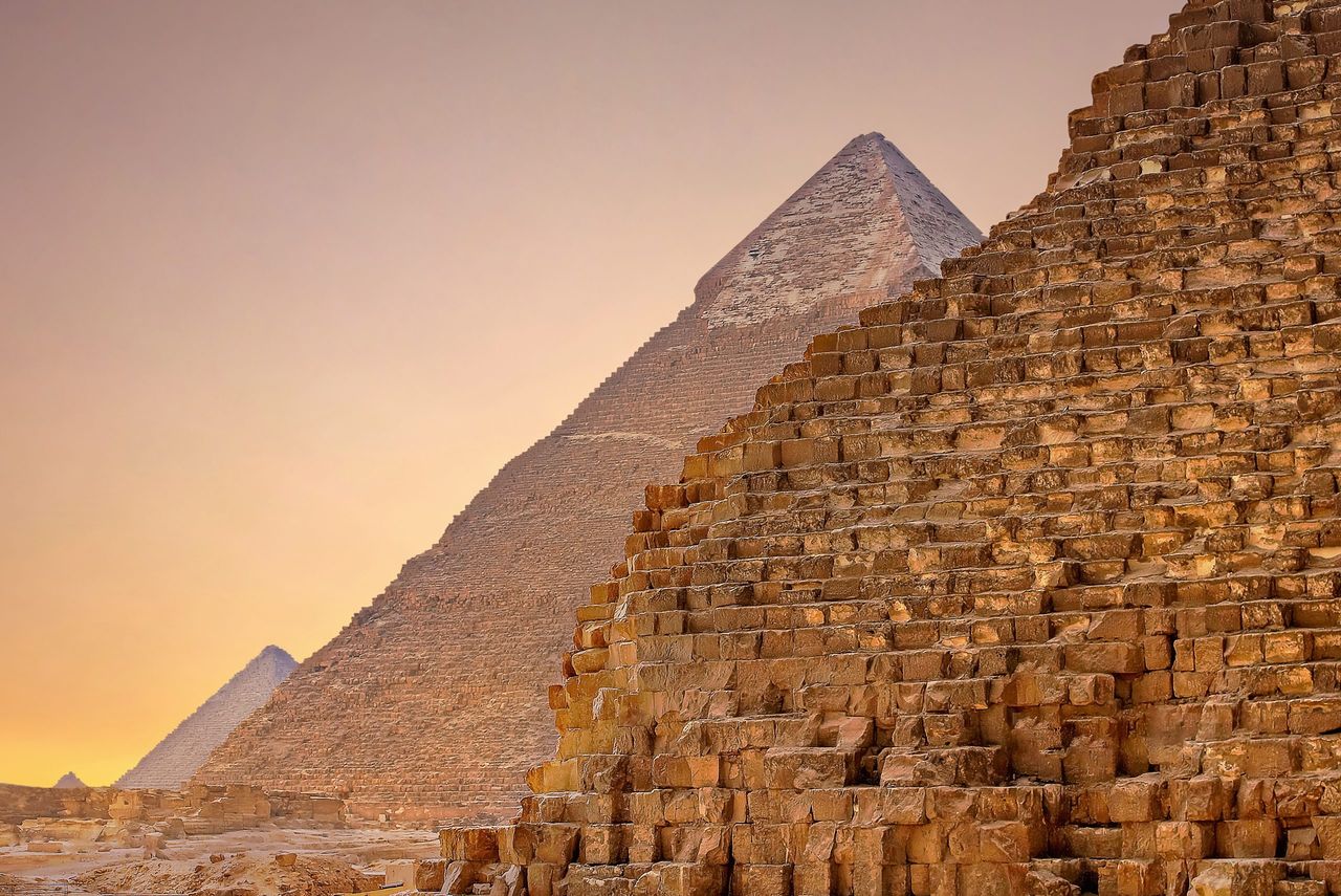 A side view of the Pyramids of Giza, Egypt, at sunset.