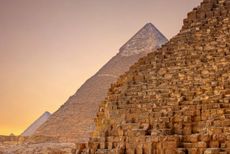 A side view of the Pyramids of Giza, Egypt, at sunset.