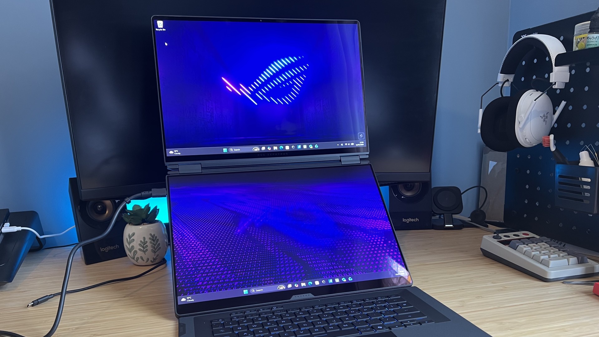 Asus ROG Zephyrus Duo gaming laptop set up in dual-screen mode on a wooden desk