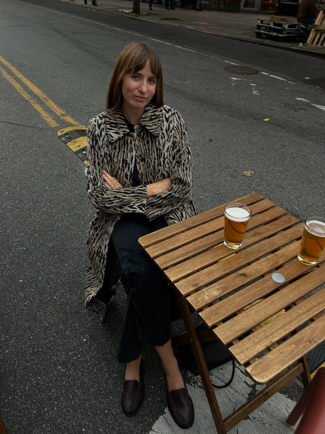 Lizzy wears a leopard print coat from rixo with black jeans and brown loafers