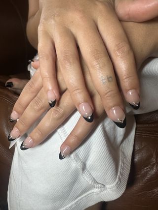 Raye wearing the black French nail trend