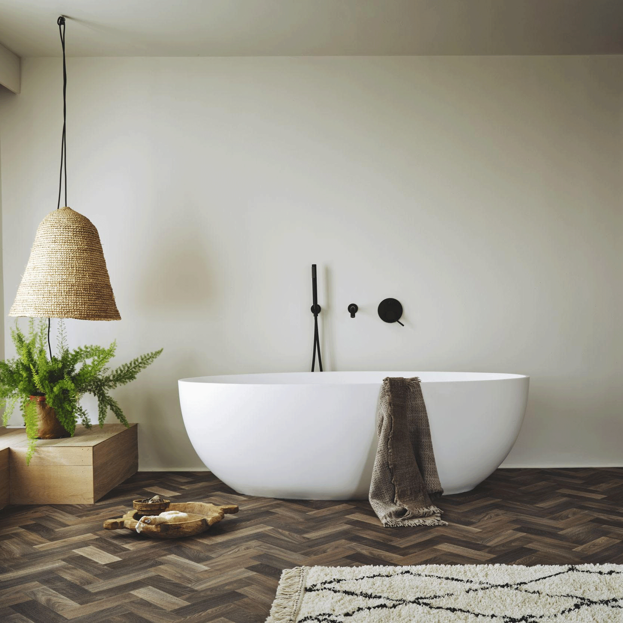 Frestanding bath in bathroom with herringbone vinyl flooring