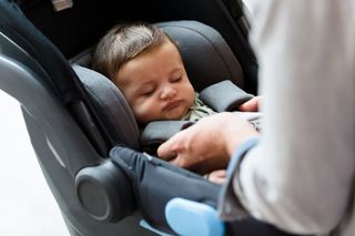 A baby is sleeping in a car seat