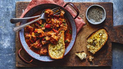 Pork goulash on a wooden board with garlic bread
