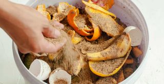 person making compost in the kitchen using orange peels banana peels and eggshells
