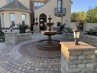 Paved walkway and driveway with a central fountain