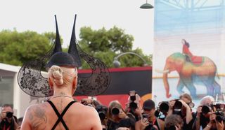 Lady Gaga wears a black lace headpiece by Philip Treacy at the Joker premiere.