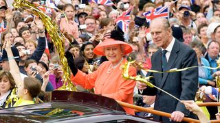 Queen Elizabeth II and Prince Phillip the Duke of Edinburgh ride along the Mall in an open top car on their way to watch a parade in celebration of the Golden Jubilee on June 4, 2002.