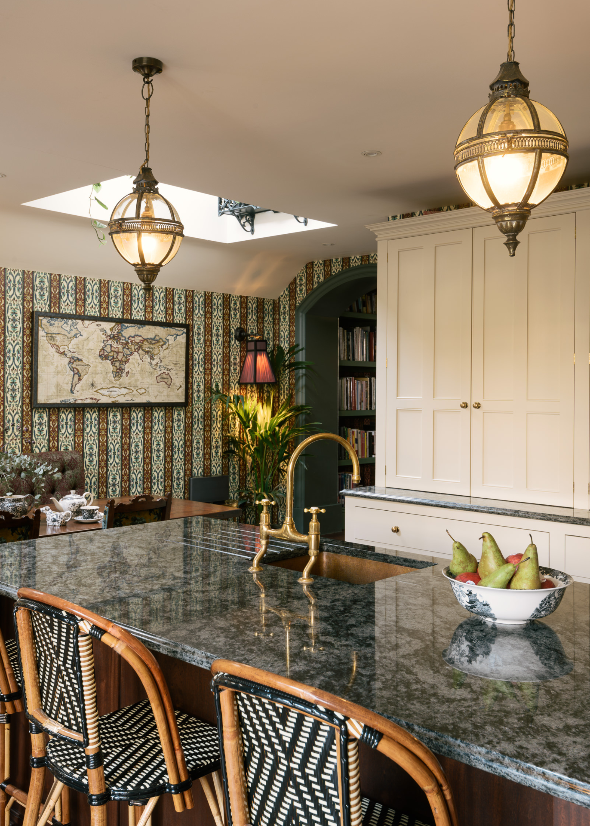 a traditional english kitchen in a maximalist design with wallpaper and granite counters