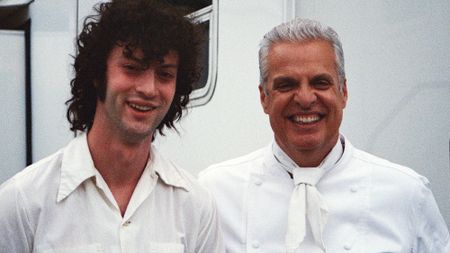 Dominic Sessa on the left, standing with Eric Ripert behind the scenes on the set of Tony