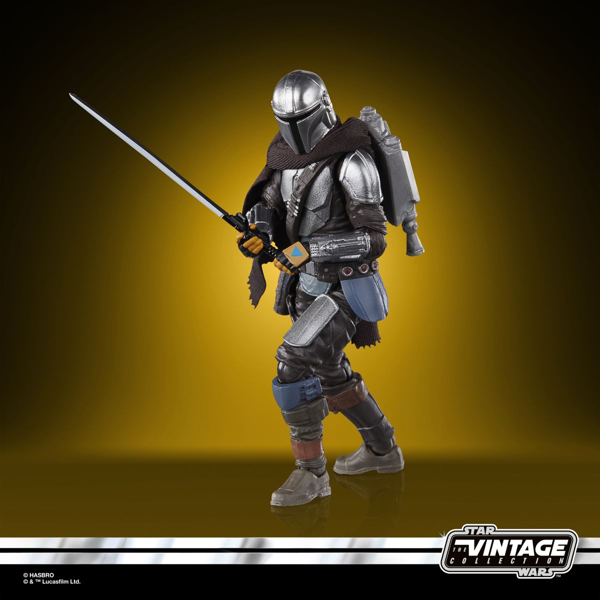 The Vintage Collection Mandalorian figure, posed on a yellow and black background