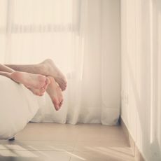 Feet of couple lying in bed
