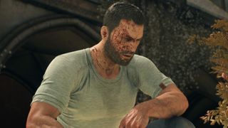 Kyle Crane, the protagonist from Dying Light: The Beast, sitting outside after an injury. He's in a plain white t-shirt and jeans, squinting with a bloody face.