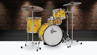 Yellow Gretsch Catalina Jazz drum set with Paiste cymbals against a red brick wall