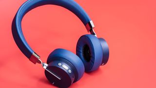 Stylish blue headphones on a red background.