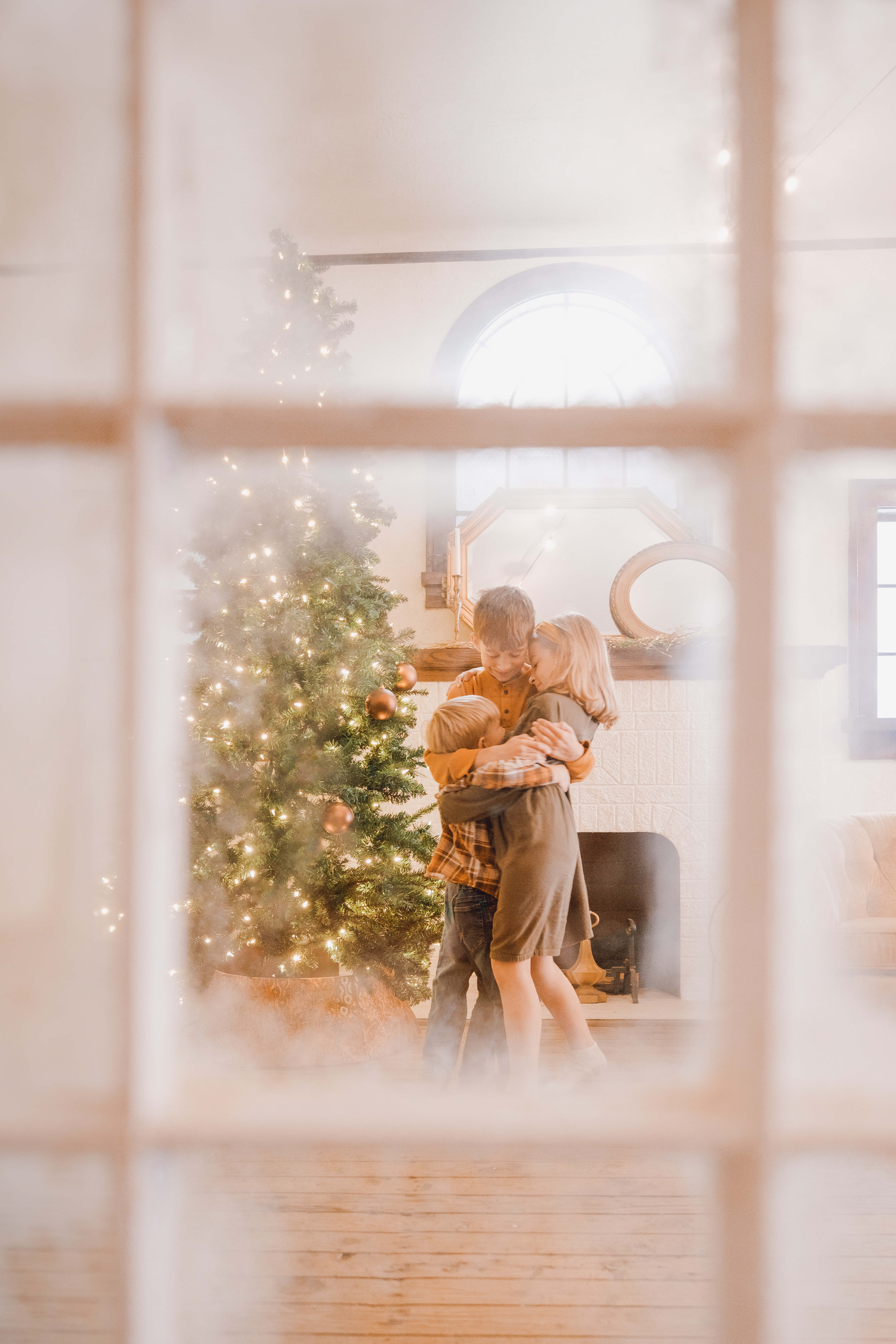 A snowy window frames a cozy Christmas scene