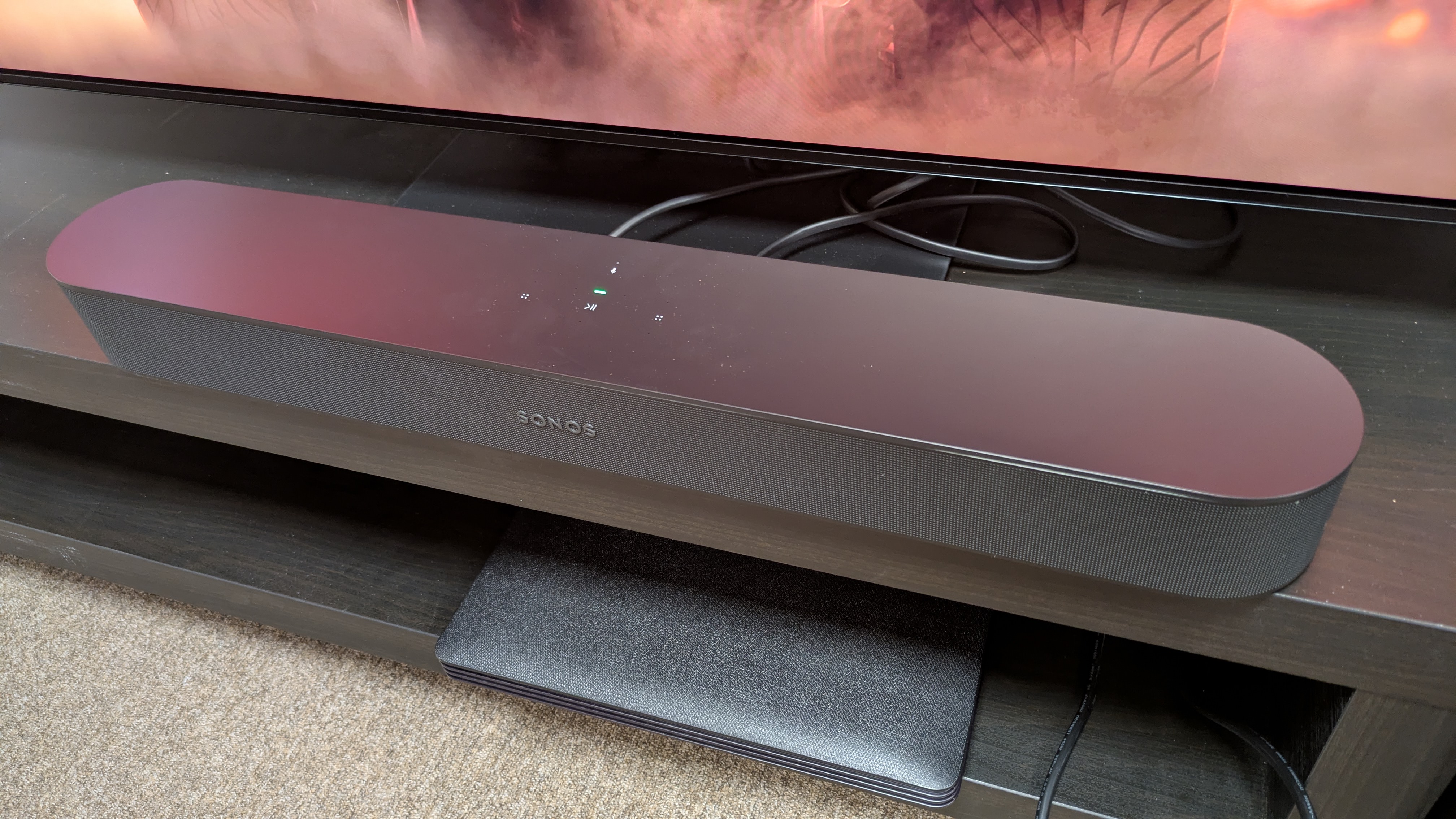 Sonos Beam (Gen 2) on dark wood stand 