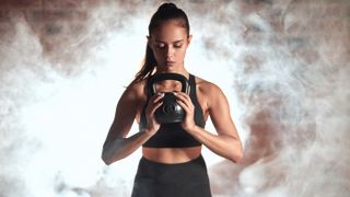 a photo of a woman holding a kettlebell