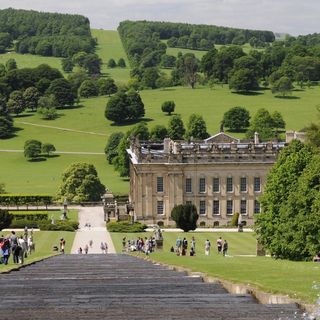 chatsworth house with lawn area and trees
