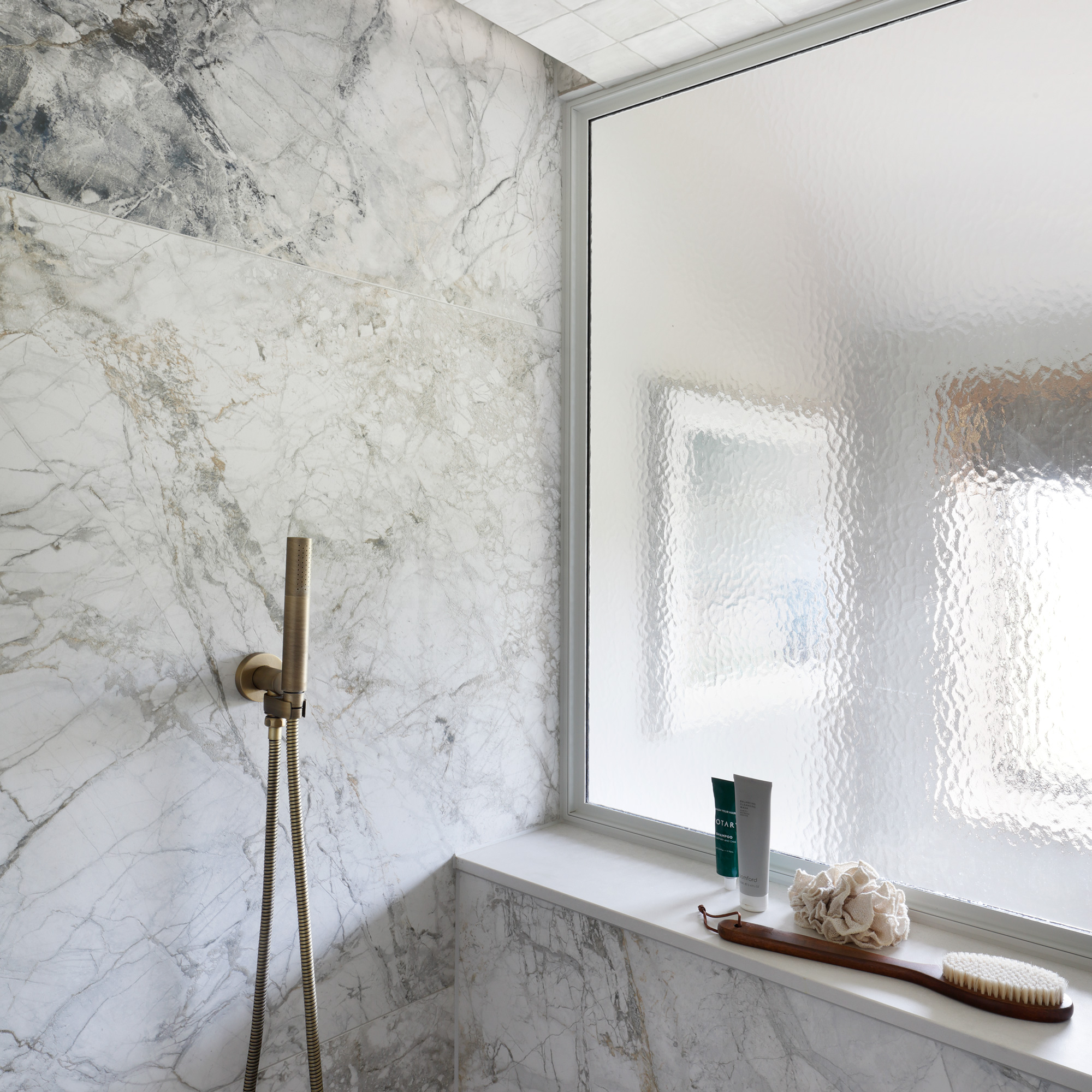 a glass internal window in a shower space providing light in an otherwise dark space