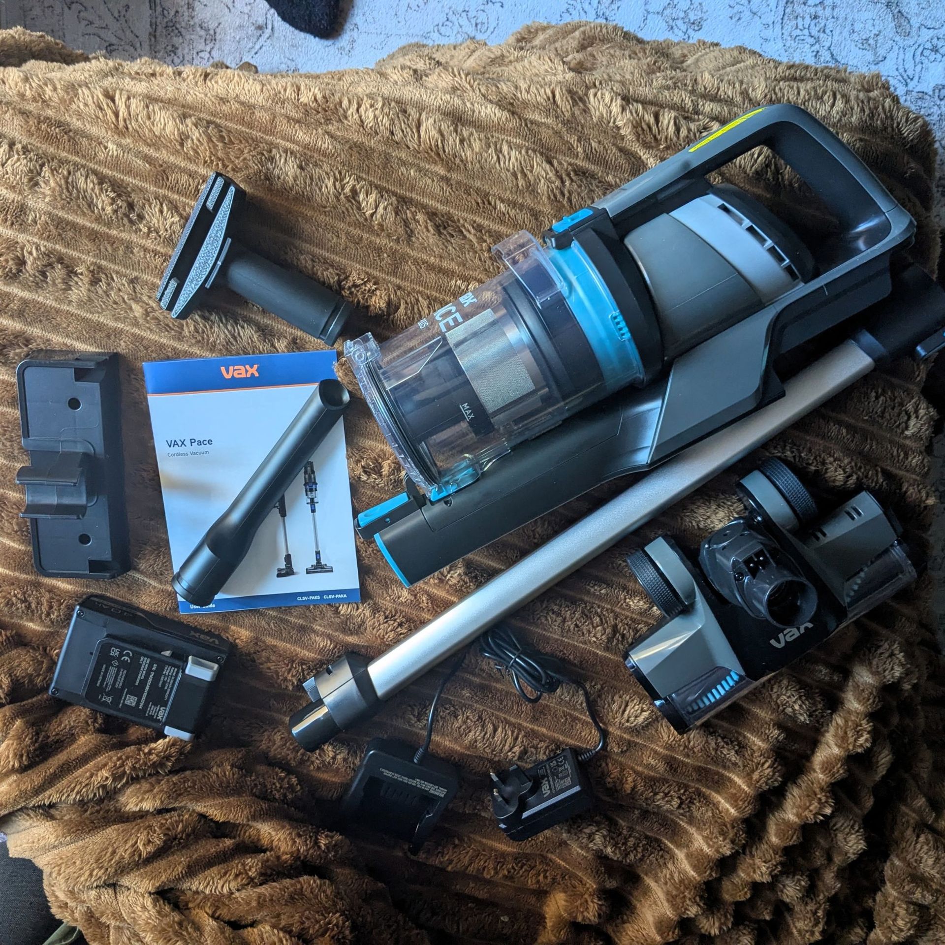 VAX Pace Plus Cordless Vacuum Cleaner and components laid out on orange throw 
