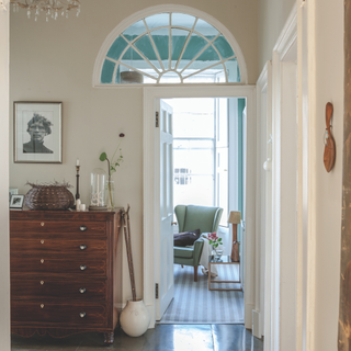 a cream and white painted hallway with a door open to the living room