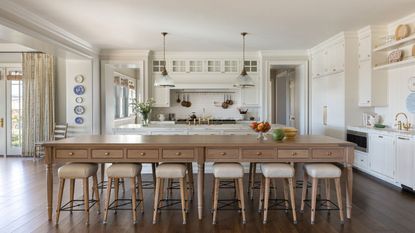 kitchen white units wooden island table and hardwood floor