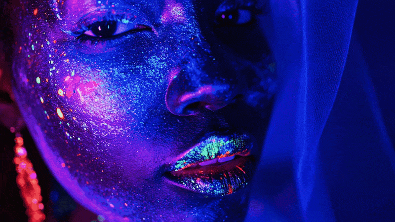 Firefly video created using the prompt "woman withluminous dark skin and iridescent clothing looks towards the camera high fashion"