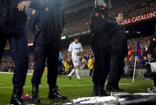 Police officers at Camp Nou watch the crowd as Luis Figo prepares to take a corner on his return to Barcelona as a Real Madrid player in 2002.