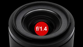 Close-up of a camera lens with a prominent red circle displaying the f-stop value f/1.4 against a black background