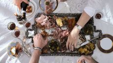 hands reaching at food on an antipasti board