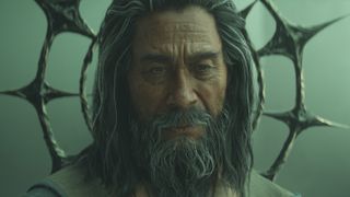 Old man with a long gray beard and flowing hair sits contemplatively. He wears a crown-like structure with spikes, emitting a mysterious and wise aura.