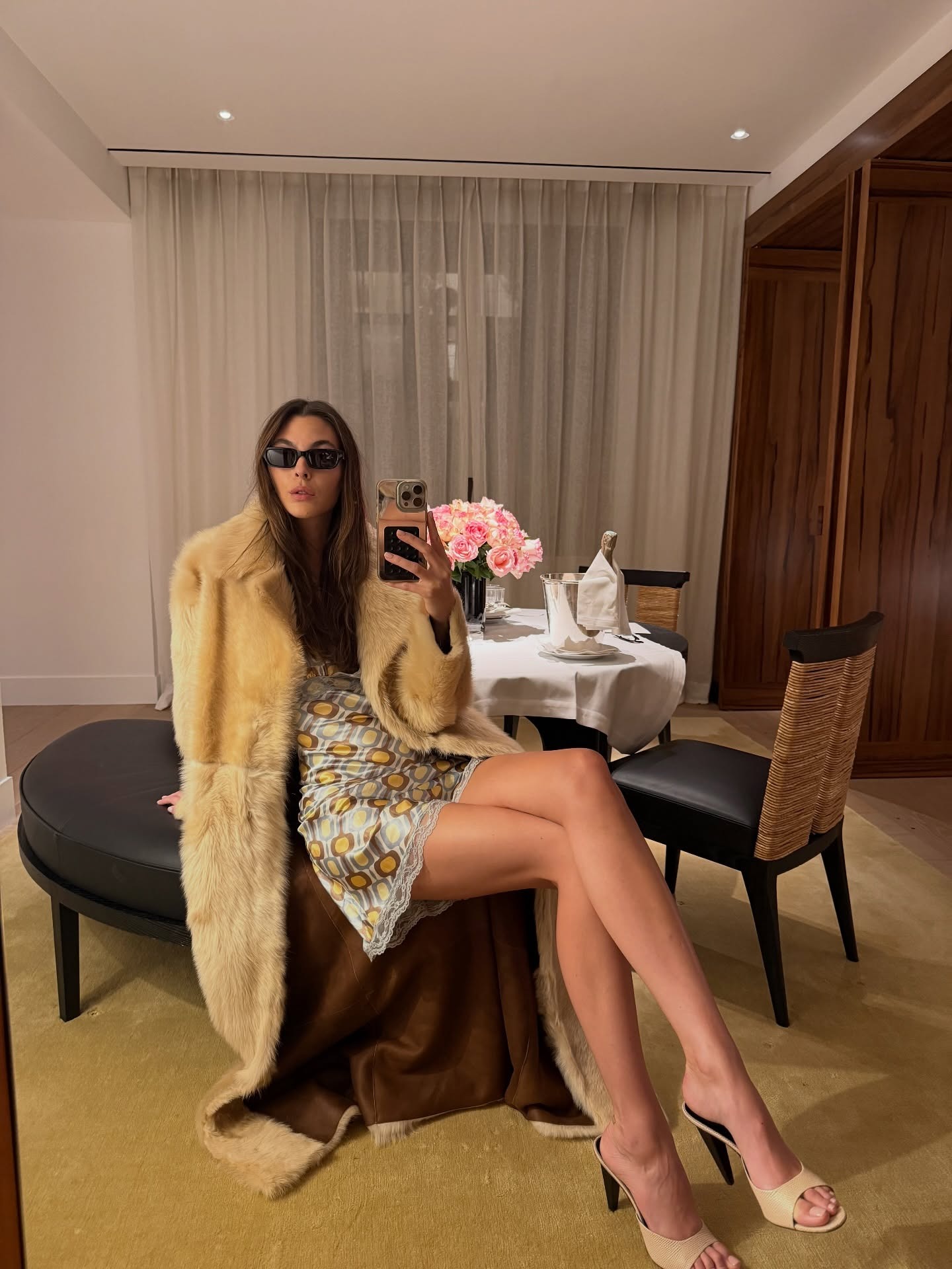 Vittoria Ceretti wearing a fur coat and patterned lace slip dress with pumps.