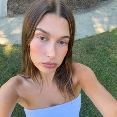 A selfie of Hailey Bieber wearing a blue strapless top