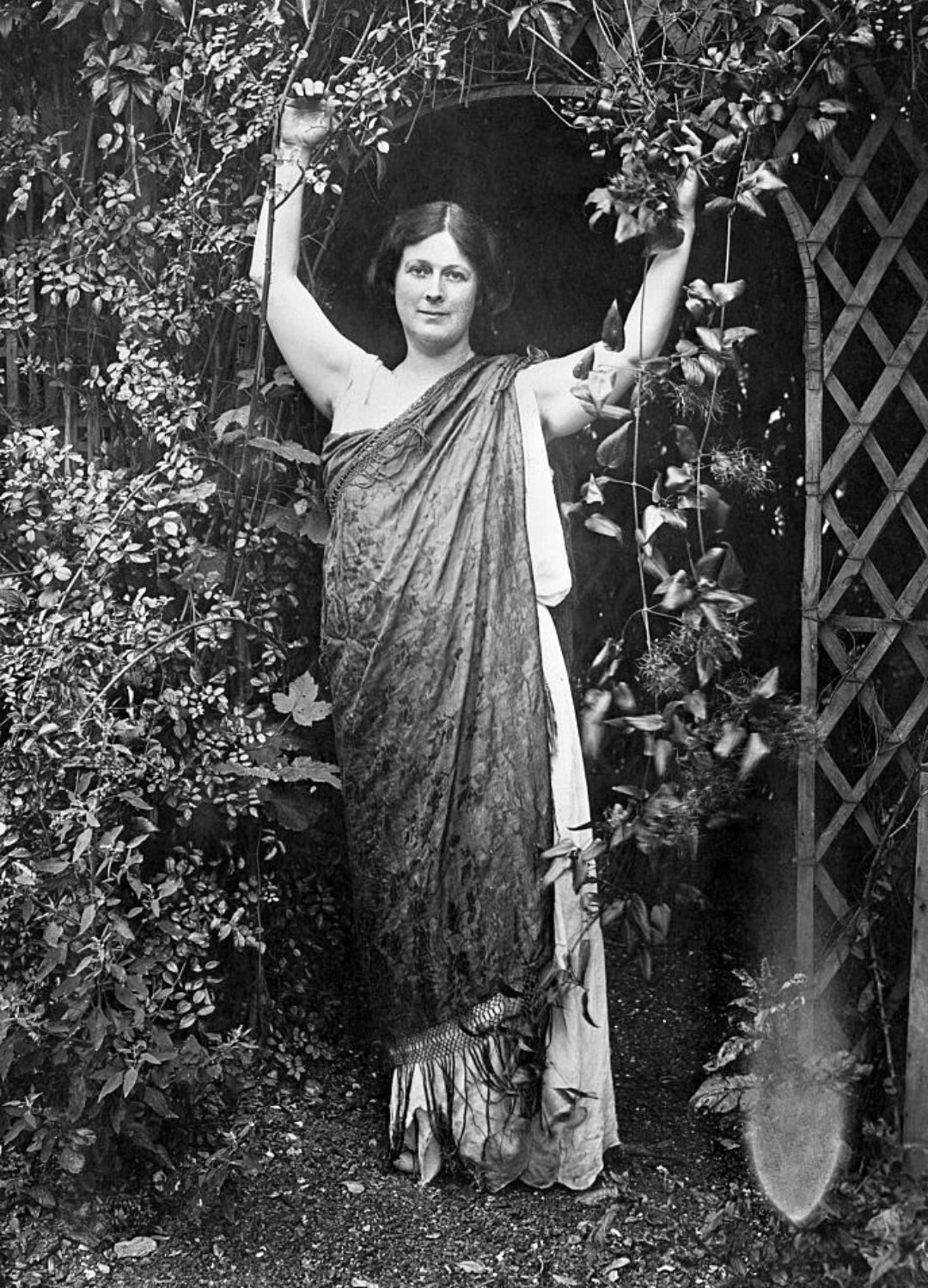 A black and white photo of Isadora Duncan in a garden