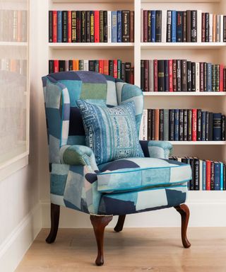 Blue armchair with bookcase behind