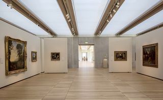 Spacious art gallery with white walls and wooden flooring