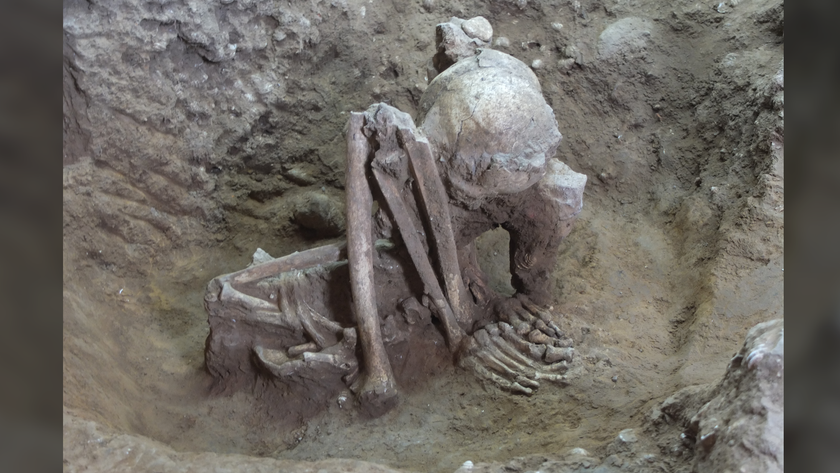 a tightly crouched human skeleton in the ground