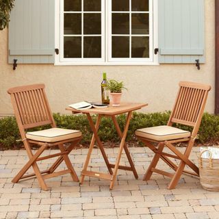 A wooden bistro set on a terrace